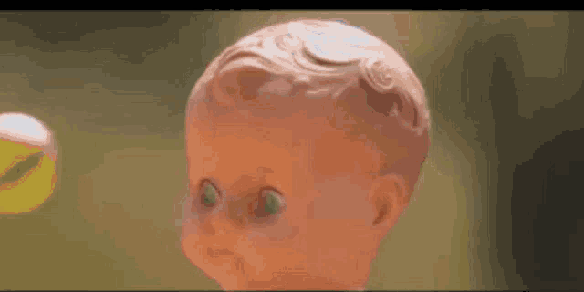 a doll with green eyes is looking at the camera .