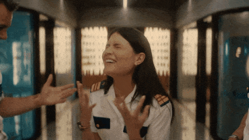 a woman in a military uniform laughs while a man tries to stop her