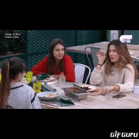 a group of women are sitting at a table with plates of food and a gif that says gifguru on the bottom