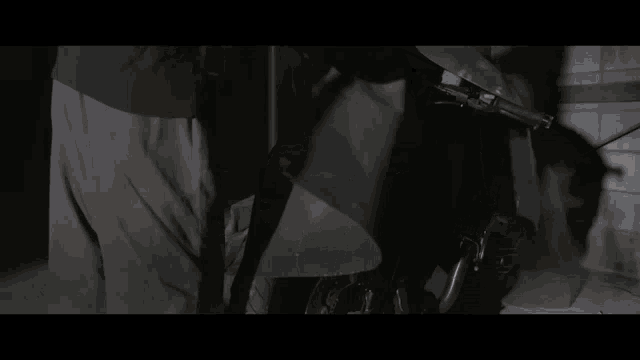 a person standing next to a motorcycle in a dark area