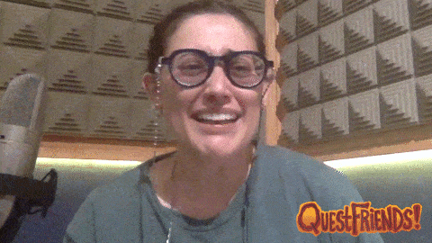a woman wearing glasses is crying in front of a quest friends sign