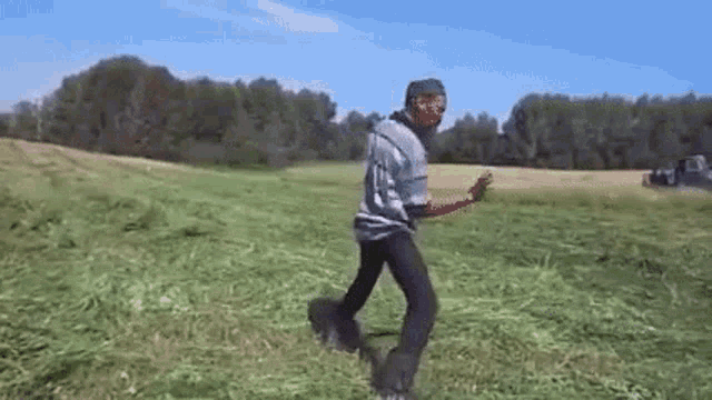 a man is standing in a field of tall grass .