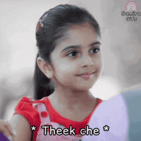 a little girl is smiling and looking at herself in a mirror with the words theek che written below her