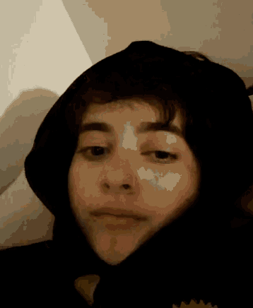 a close up of a person wearing a black hooded jacket