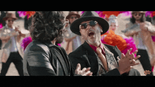 a man in a hat is talking to another man in a suit and tie