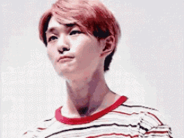 a young man with red hair and a striped shirt is looking up .