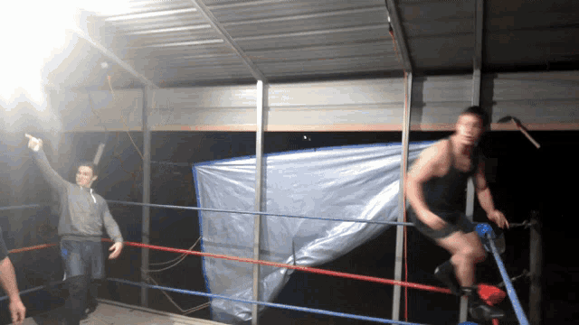 two men in a wrestling ring one pointing