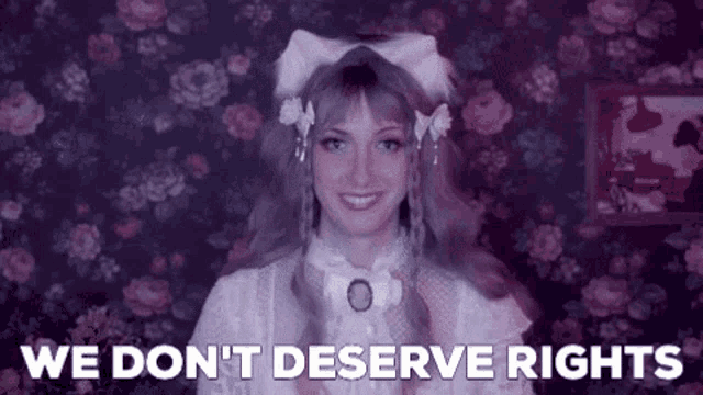 a woman with pink hair and a bow in her hair is smiling and saying `` we don t deserve rights '' .
