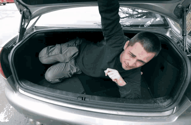a man laying in the back of a car