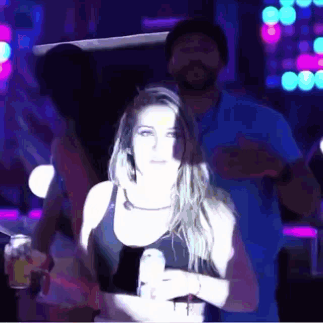 a man and woman are dancing in a dark room with purple lights