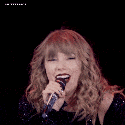 taylor swift is wearing a black sequined top and has red lipstick on her lips .