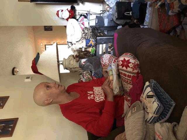 a bald woman wearing a red sweater that says angels