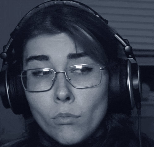 a woman wearing glasses and headphones making a funny face
