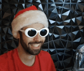a man wearing sunglasses and a santa hat is smiling