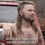 a shirtless man with a mullet and a beard is smoking a cigarette in front of a car .