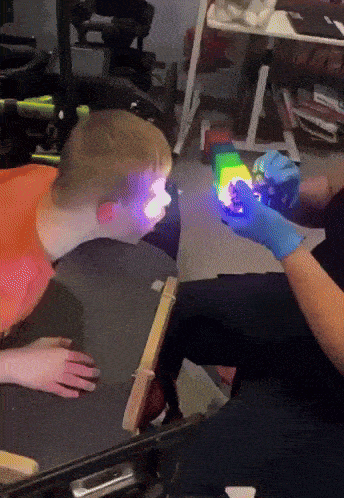a person is holding a cube in front of a child 's eyes