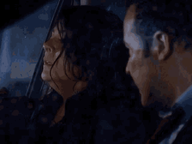 a man and a woman are sitting in a car .