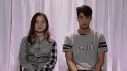 a man and a woman are sitting next to each other .