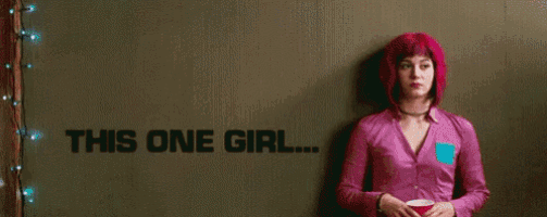 a man and a woman are standing next to each other in front of a wall that says `` one girl '' .