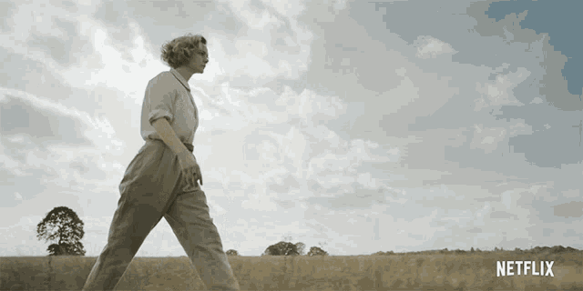 a woman is walking in a field with a netflix logo in the corner