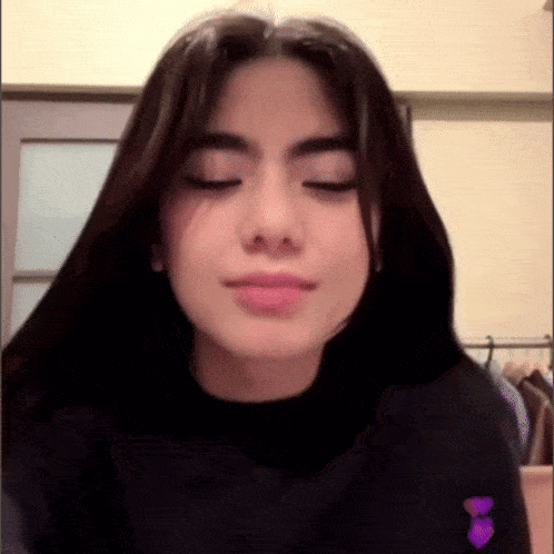 a close up of a girl with her eyes closed .
