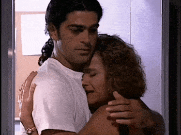 a man and a woman hugging each other in a room