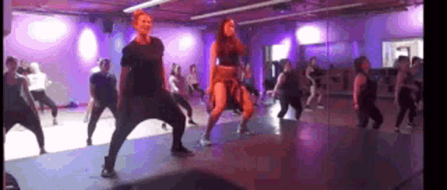 a group of people are dancing together in a dance studio .