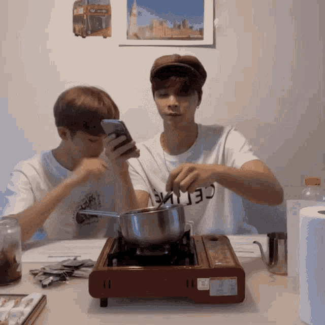 a man wearing a celine shirt is cooking on a small stove