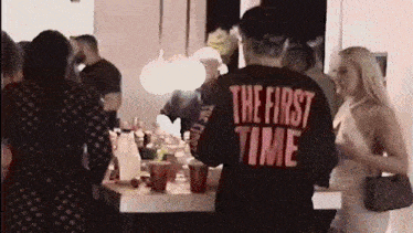 a man wearing a black shirt that says the first time on the back