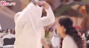 a man and a woman are dancing together in a crowd .