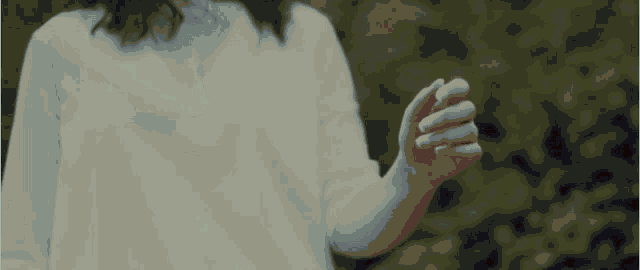a woman is dancing in a dark room with her arms outstretched