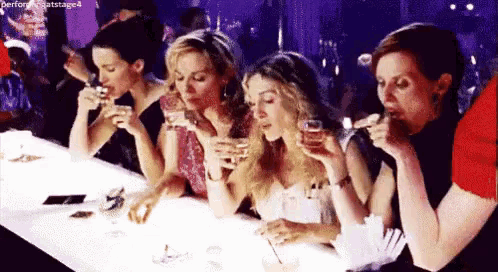 a group of women sitting at a bar drinking wine .