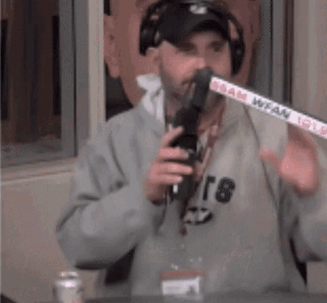 a man wearing headphones is holding a microphone with a sign that says wfam 101.9