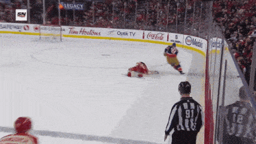 a hockey game is being played in a stadium with ads for coca cola and tim hortons
