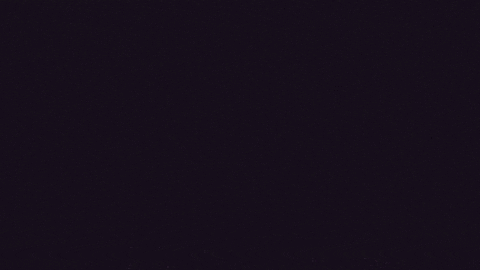 a purple glowing object is coming out of a hole in the ground in a dark room .