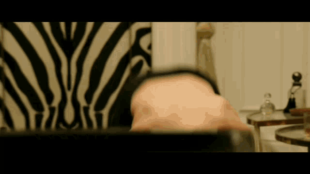a person 's head is visible in front of a zebra print wall
