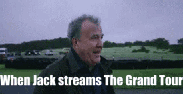 a man in a jacket is standing in front of a field with the words `` when jack streams the grand tour '' .