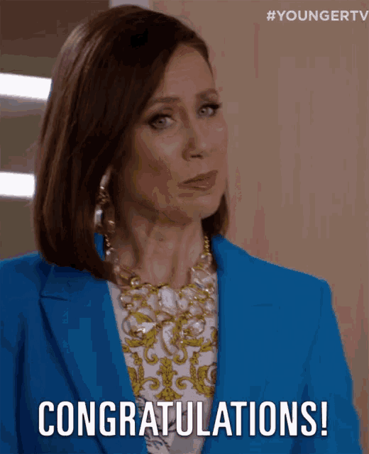 a woman in a blue jacket is congratulating someone