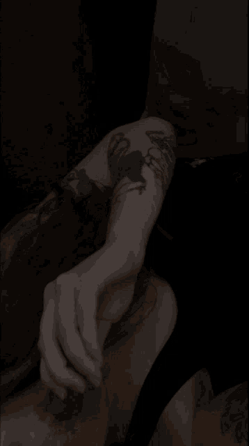 a person with a tattoo on their arm is holding something in their hand