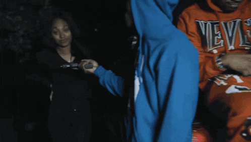 a man wearing a blue hoodie with the letter k on it takes a picture of a woman