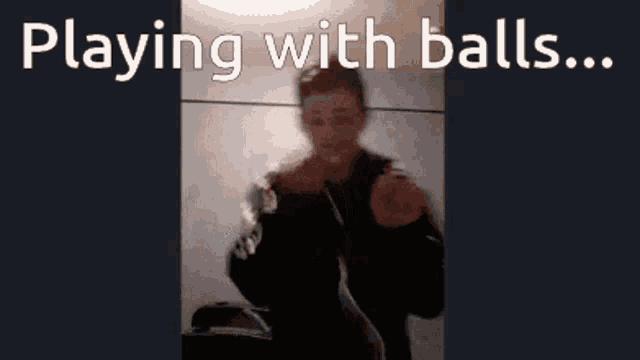 a man in a black jacket is playing with balls ..