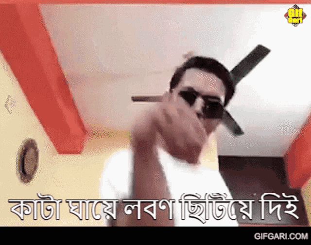 a man wearing sunglasses is standing in a room with a ceiling fan and making a funny face .