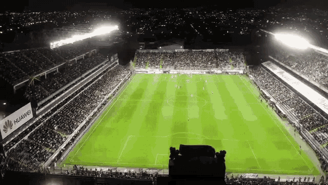 an aerial view of a soccer field with a huawei advertisement in the stands