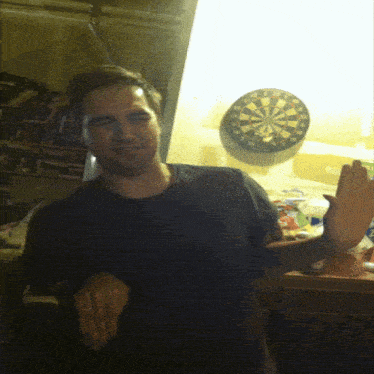 a man stands in front of a dart board that says ' x ' on it