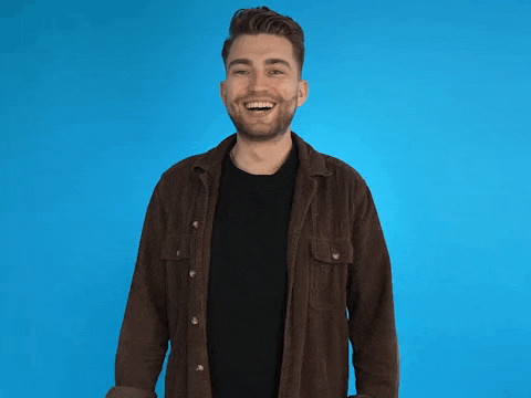 a man in a brown shirt is giving a thumbs up