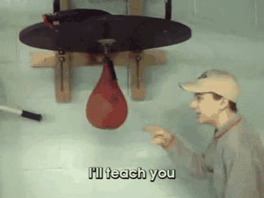 a man is pointing at a punching bag and says i 'll teach you