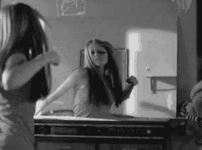 a woman is standing in front of a mirror .
