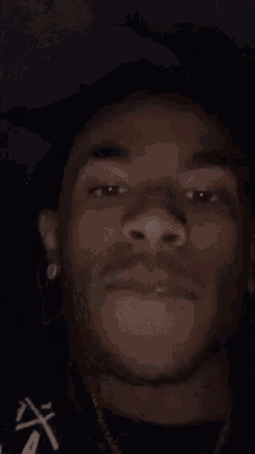 a close up of a young man 's face with his hand on his head .