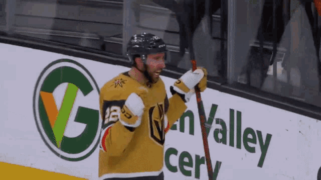 a hockey player stands in front of a sign that says golden valley