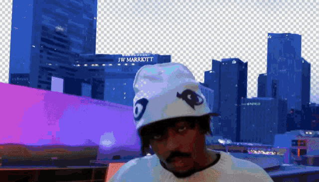 a man in a white hat stands in front of a jw marriott building